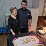 Simone Huhtala (left) gets a picture taken with Deep, the man responsible for baking her birthday cake for her 103rd party, held Friday, Feb. 20, at Vernon&rsquo;s Schubert Centre. (Roger Knox - Morning Star)
