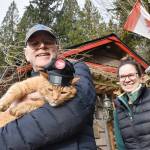 Whonnock resident Paul Stanley holds Sid, the honorary postmaster for the Whonnock Post Office, with the official postmaster Mareesa Kelly. (Colleen Flanagan/The News)